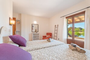 Un dormitorio con dos camas, una silla, una escalera, un aparador y una ventana con vistas.