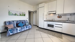 A modern kitchen with white cabinets, a built-in oven, and a countertop with a sink.