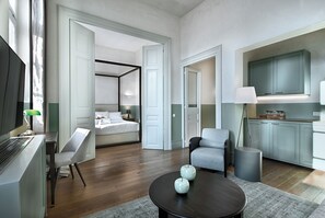 Une chambre d’hôtel moderne comprenant un lit, un coin salon avec une table et une kitchenette.