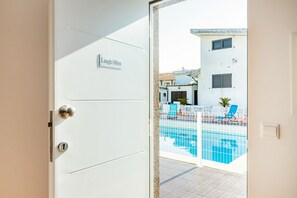 A white door with a sign that reads "Laugh Often."
