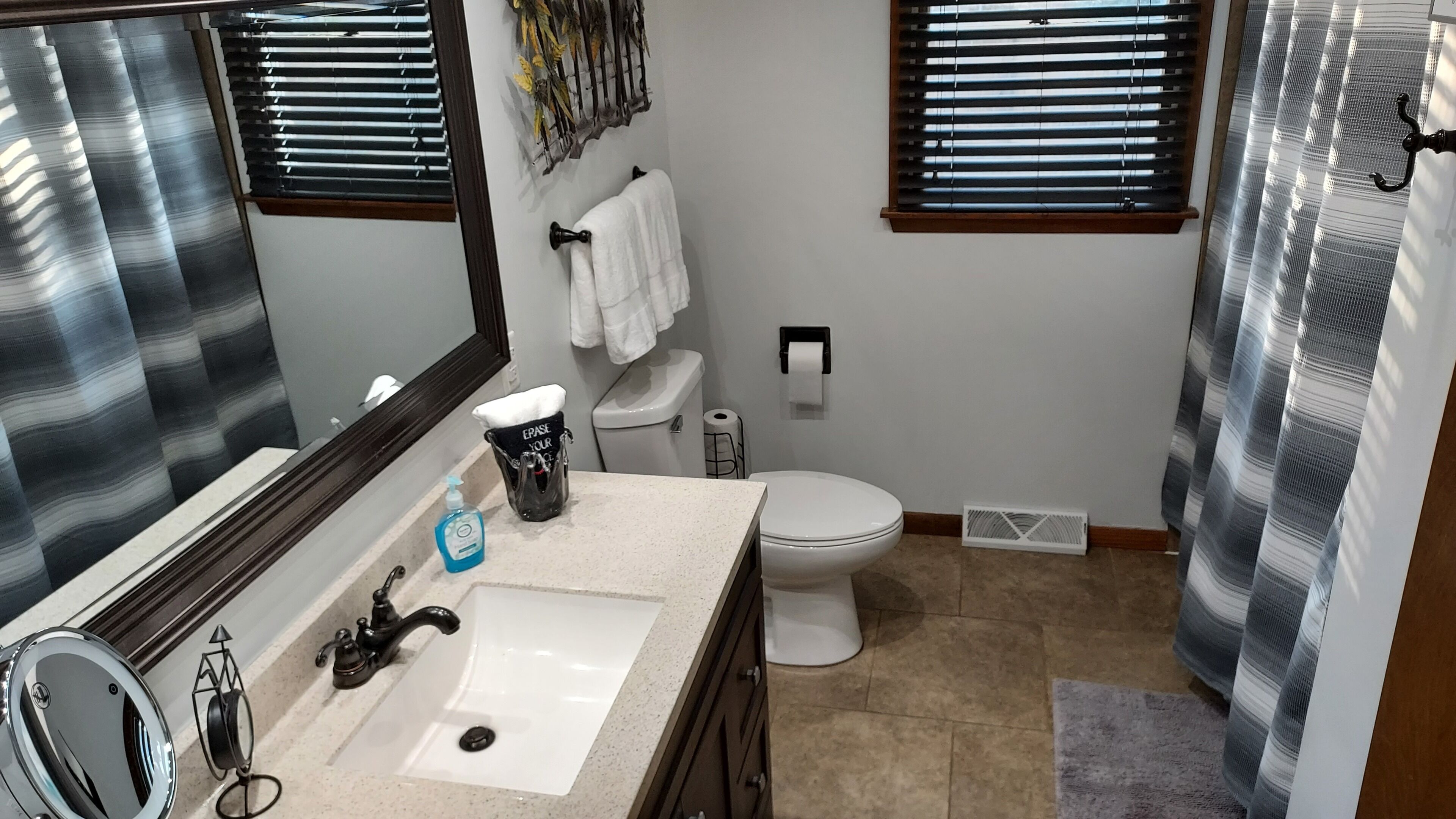 Een badkamer met wastafel, toilet en douche.
