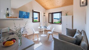Eine moderne Küche mit Essbereich, Holzboden und großen Fenstern mit Aussicht.