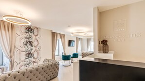 Rebedor modern d'hotel amb taulell de recepció, zona de seients i obra d'art decorativa a la paret.