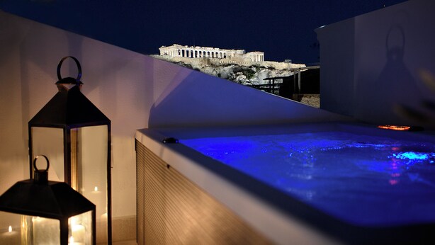 Une terrasse sur le toit avec un jacuzzi, une lanterne et une vue sur un bâtiment historique.