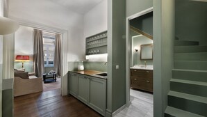 Une cuisine moderne avec des meubles gris, un plan de travail en bois et un meuble à vin intégré.