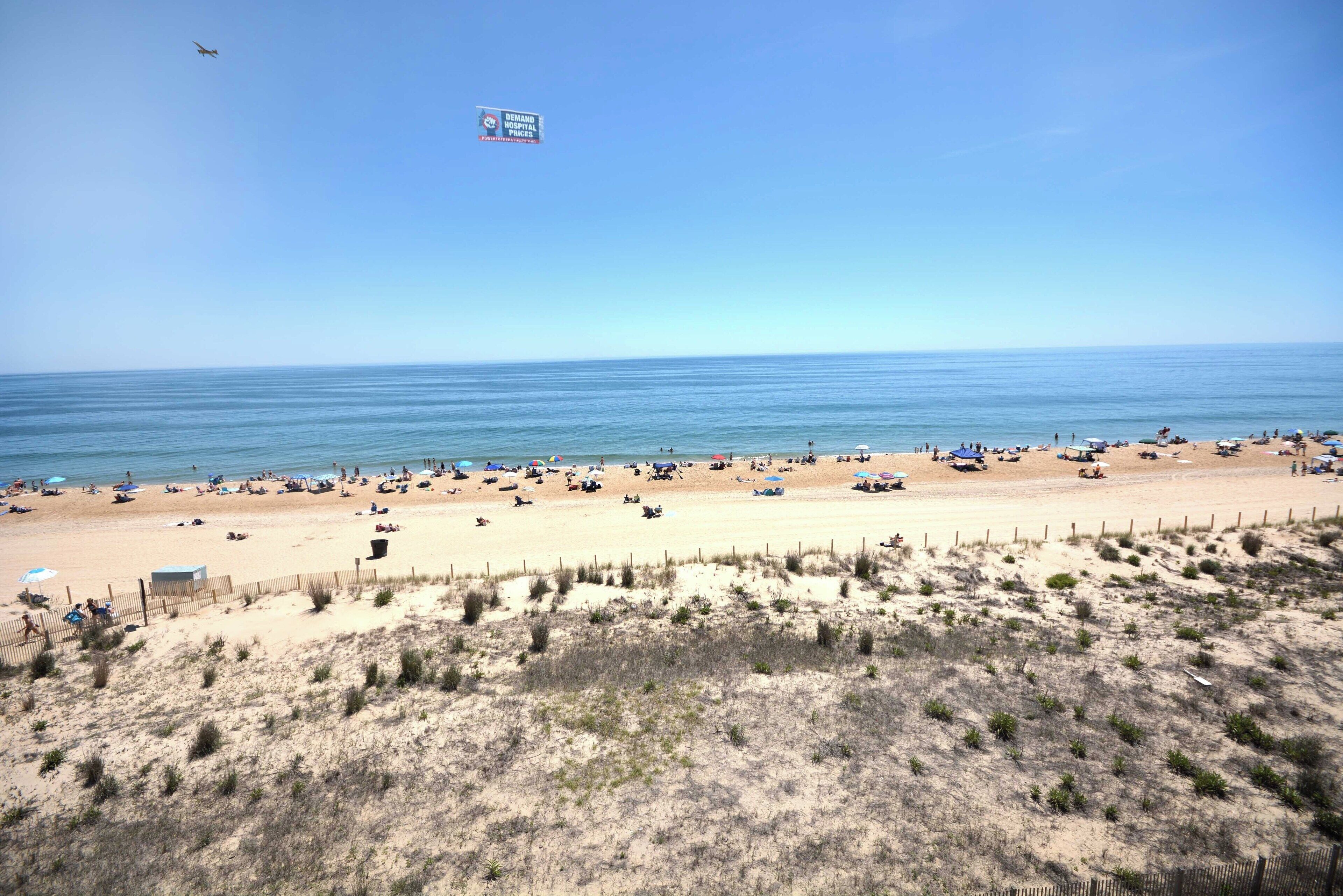 A beach with people, tents, and a clear sky.