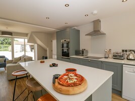 Una cocina moderna con una isla central, electrodomésticos integrados y vistas al exterior.