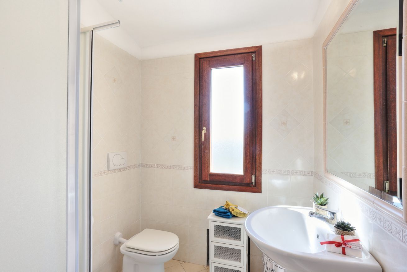 A bathroom with a toilet, a sink, and a shower area.