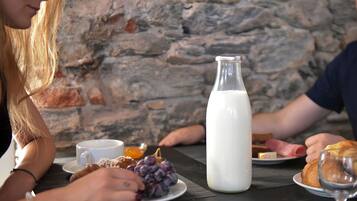 Una mesa con platos de comida, un vaso de leche y una botella de leche.