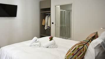 Ein Hotelzimmer mit Bett, Kleiderschrank und Duschbereich.