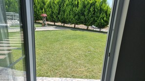 A view of a well-maintained lawn with a birdbath and a metal fence in the background. - Sidelya Apart (Gökçeada)