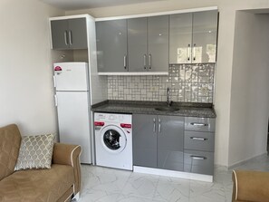 Apartemen Standar, balkon | Dapur kecil pribadi | Lemari es, kompor, dan peralatan masak/sendok-piring