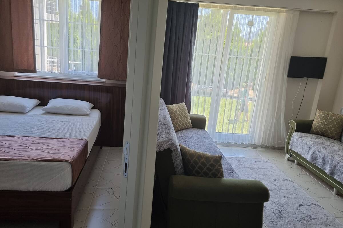 Un dormitorio con cama, sofá y televisor.