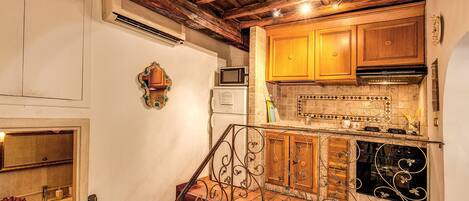 A kitchen with wooden cabinets, a tiled backsplash, and a stainless steel range hood.