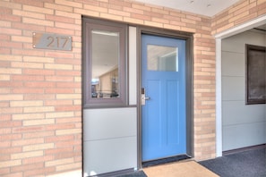 Stylish entrance with a large window above the door and a black mat at the entrance.