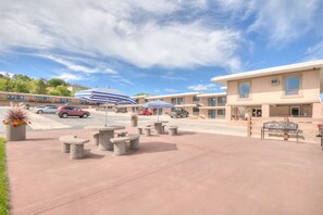 Guests can relax in outdoor seating areas with stone benches and tables.
