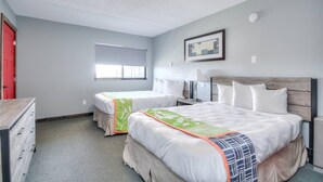 A bedroom with two beds, a dresser, a window, and a framed picture on the wall. - 1BR with 2 beds and a kitchen on the 2nd floor (Rapid City)