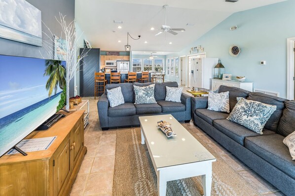 A modern living room with a grey sofa set, a flat-screen TV, and a coffee table.