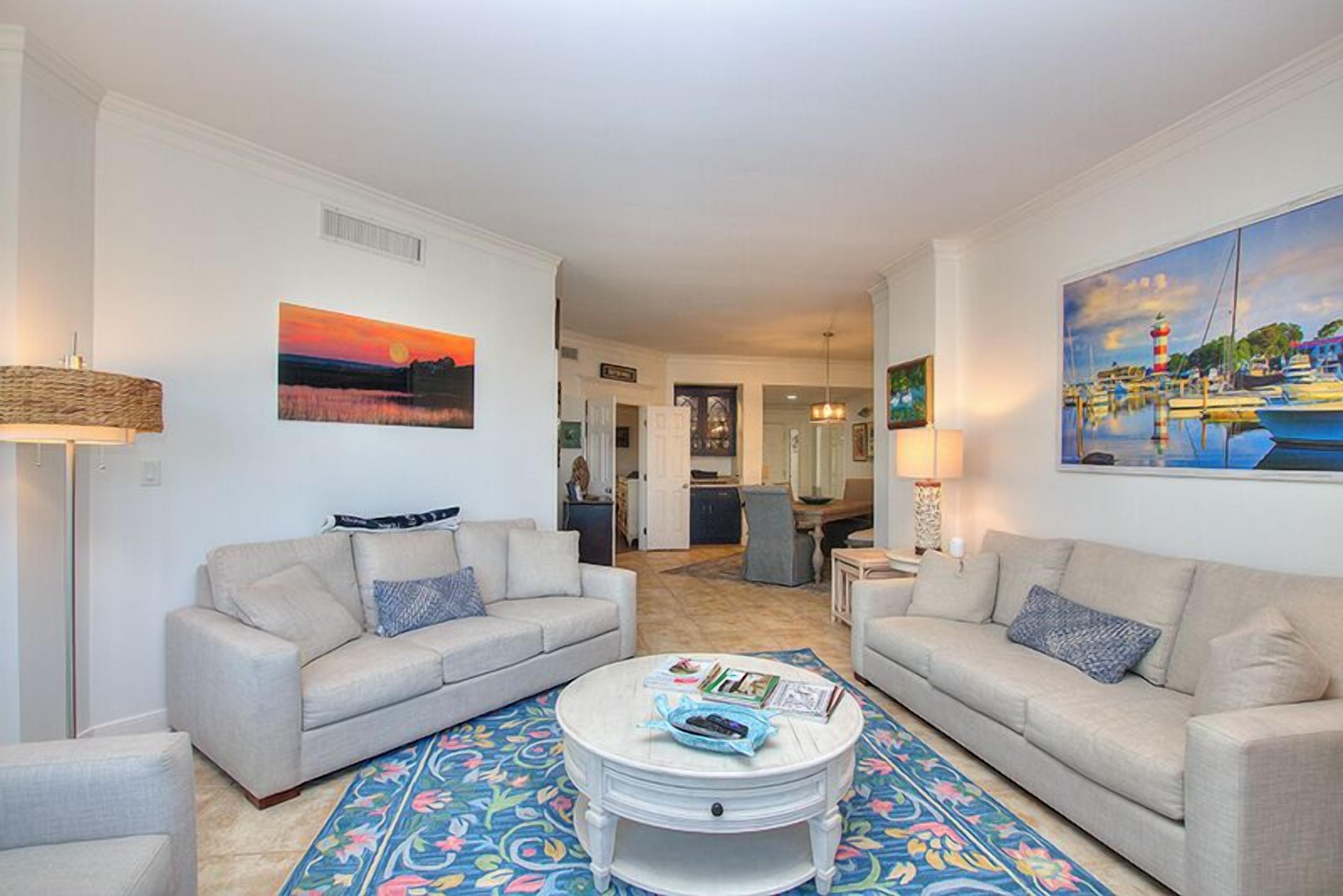 A living room with two sofas, a coffee table, and a colorful rug.