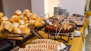 A buffet with various breads and pastries.