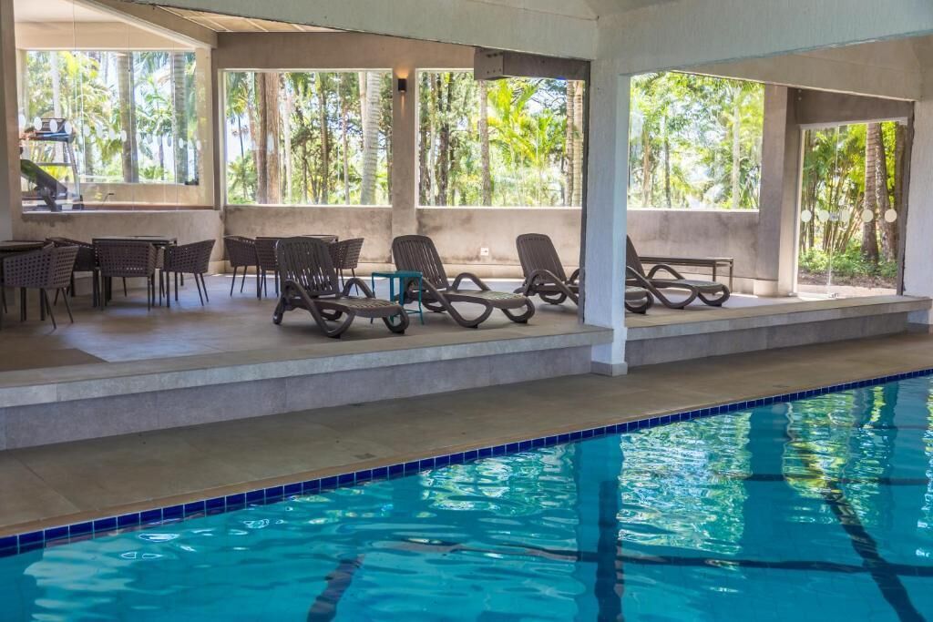 A pool area with lounge chairs and a bar.