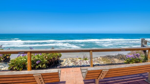 A wooden deck with benches overlooking a beach with waves and a clear blue sky. - Ocean Dreams – Cozy Family Condo Near Beach, Pool & Tennis in Solana Beach (Solana Beach)