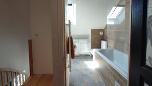A modern kitchen with a built-in washing machine, a large window, and a hexagonal tile floor. - Old school in the heart of a village near Puy du Fou (Sèvremoine)
