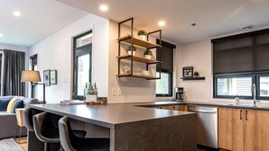 Una cocina moderna con una isla central, estantes empotrados y un ventanal con vistas.