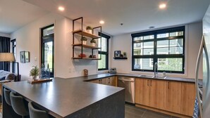 Una cocina moderna con una isla central, armarios de madera y un ventanal que proporciona luz natural.