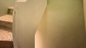 A staircase with a white railing and a light-colored wall. - Charmant et Spacieux Appartement T3 en Bord de mer (Canet-en-Roussillon)