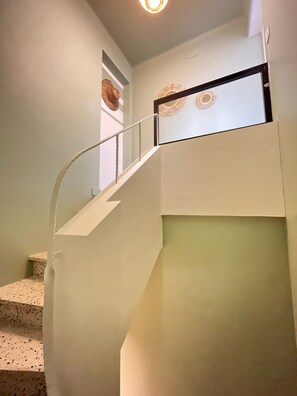 Eine Treppe mit weißer Handläufe und einer hellen Wand.