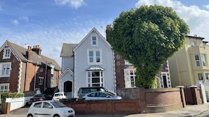 A residential street with houses, a tree, and parked cars. - Between the beach and the shops (Portsmouth)