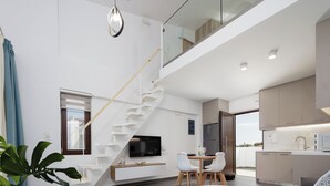 A modern apartment with a staircase leading to a loft, a dining area, and a kitchen. - Coconut Palm Paradise (Rethymno)