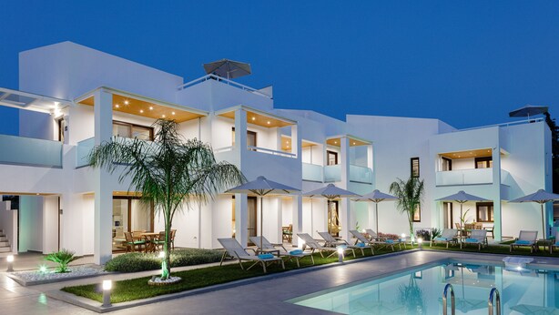 A modern hotel with a pool, outdoor seating, and umbrellas. - Coconut Palm Paradise (Rethymno)