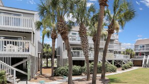 A multi-story building with balconies, palm trees, and a pathway leading to the entrance. - Beach View, Pet Friendly, 3 BR End-Unit Steps from Beach ~ Sand and Surf (Cape San Blas)