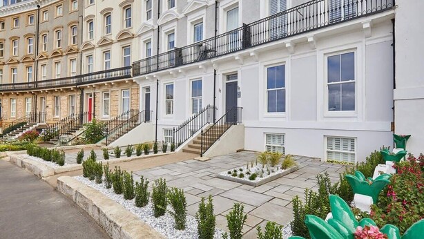 A row of townhouses with individual front gardens, white facades, and black railings. - Host & Stay | The Royal Hideaway (Whitby)