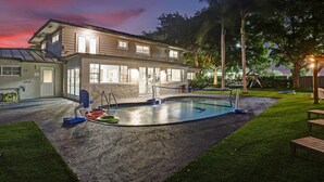 A two-story house with a swimming pool, a covered patio, and a playground. - 8BR Family Resort with Pool & Playground (Pompano Beach)
