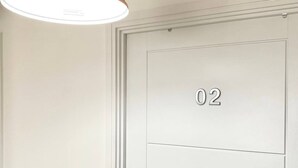 A white door with the number "02" on it, a light fixture above, and a white wall. - Impeccable 2 Bedroom House in Bicester (Bicester)