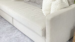 A light-colored sofa with a grey throw blanket and three white pillows. - Impeccable 2 Bedroom House in Bicester (Bicester)