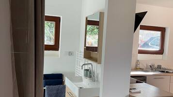 Une salle de bain moderne avec un lavabo, un miroir et un porte-serviettes.