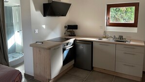Eine moderne Küche mit Geschirrspüler, Backofen und einem flachbildfernseher, der über der Arbeitsfläche angebracht ist.