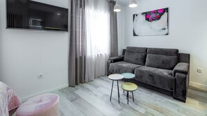 A modern living room with a grey sofa, a flat-screen TV, and a painting on the wall. - Sunshine Place (Konavle)