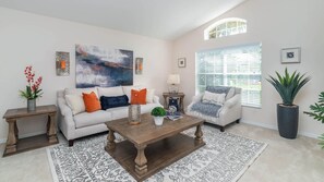 Relax in this stylish living room with a large abstract painting, a comfortable sofa, and a cozy coffee table.