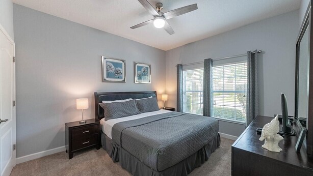 A bedroom with a bed, two bedside tables, a ceiling fan, and a window with blinds. - Last Minute Disney Getaway! Townhouse with Private Pool. Book Now! #36346 (Orlando)