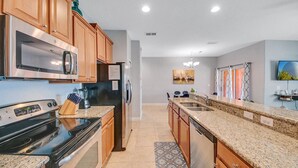 A modern kitchen with granite countertops, stainless steel appliances, and wooden cabinets.