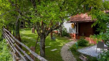 Escape to a serene cabin surrounded by lush greenery and a peaceful lawn.