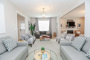 A modern living room with grey sofas, a coffee table, and a fireplace.