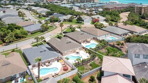 A residential area with multiple houses, a swimming pool, and a view of the ocean. - Palm Breeze - Heated Private Pool, Deeded Beach Access, Free Beach Service! (Miramar Beach)