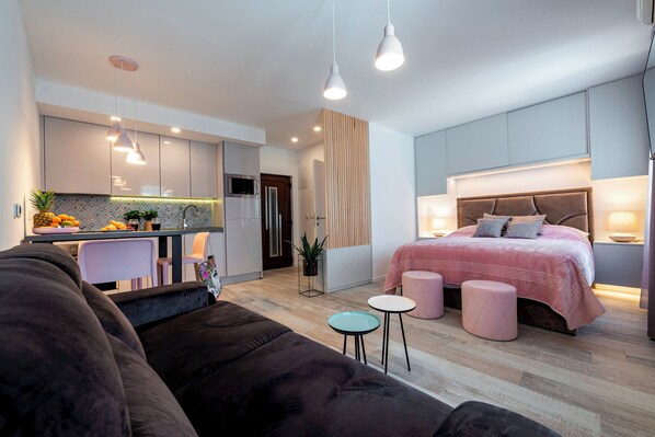 Un appartement moderne comprenant une chambre, un coin cuisine et un espace de vie.