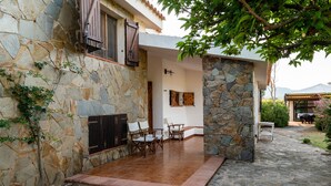 A stone building with a patio area featuring outdoor furniture. - Villa Bay Pine - direct access to Pittulongu beach, wi-fi (Olbia)